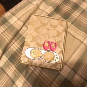Beige and gold coach wallet with a little pink